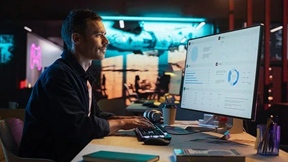 Senhor a usar computador e no ecr&atilde; gr&aacute;ficos