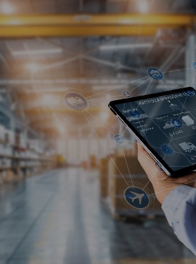 Pessoa a utilizar um tablet com interface digital sobreposta, num armazém moderno cheio de prateleiras com caixas, simbolizando a gestão digital da cadeia de abastecimento.