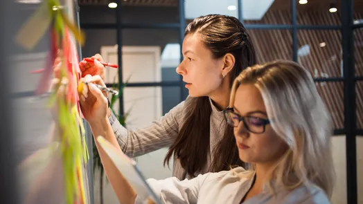 Alunas a registar apontamentos sobre Agile e Scrum em post-its