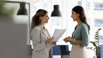 dos mujeres mantienen una conversación en una oficina