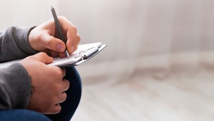 psicólogo tomando apuntes en un bloc de notas