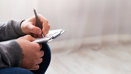 psicólogo tomando apuntes en un bloc de notas