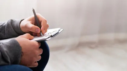 psicólogo tomando apuntes en un bloc de notas