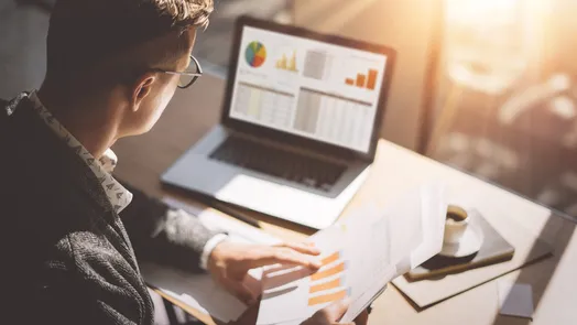 Aluno a analisar gráficos financeiros com o apoio da IA
