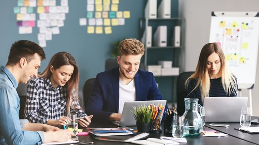 grupo de personas reunidas y poniendo en común aspectos de la gestión de un proyecto