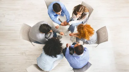 grupo de personas sentadas en círculo durante una sesión de terapia