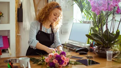 chica joven hace un ramo de flores en una floristería