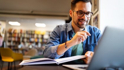 Senhor a estudar em frente a um portátil