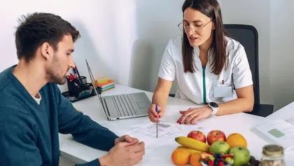 Nutrióloga creando plan de alimentación junto a un paciente