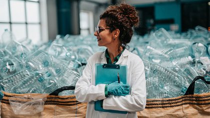 Chica con el fondo con botellas de plástico